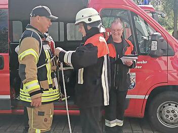Steffen Schade ( links, Kommandant der Feuerwehr Waldfenster ) und Klaus Zimmerhackl (rechts, Kommandant der Feuerwehr Oehrberg) mit einem Prüfling an der Station „Knoten & Stiche“.
