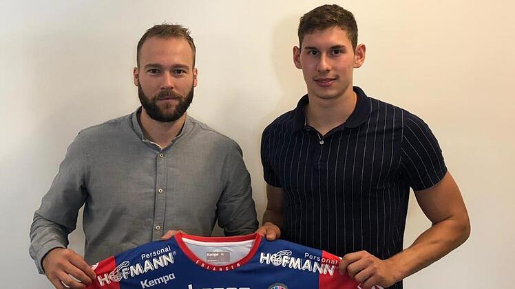 Max Jaeger (re.) präsentiert mit dem sportlichen Leiter des HC Erlangen, Kevin Schmidt, sein künftiges Trikot. HC Erlangen