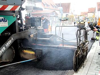Mit einer straßenbreiten Maschine wird der Asphalt aufgebracht.Richard Sänger
