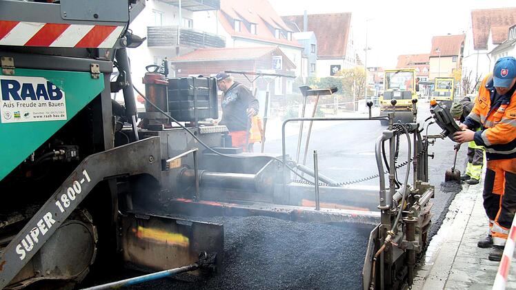 Mit einer straßenbreiten Maschine wird der Asphalt aufgebracht.Richard Sänger