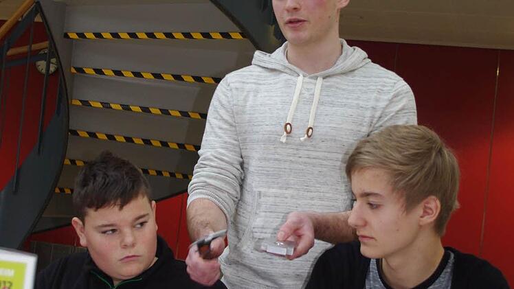 Marco Weiß (Mitte) von der Firma Scherer & Trier erklärt Nico Remmert-Hartan (links) sowie Alexander Ketterer (rechts) den richtigen Umgang mit einem Messschieber.
