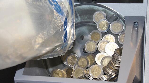 Bargeld f&auml;llt in den Schacht des Sortierautomaten. Foto: Simone Bastian