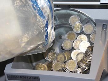 Bargeld fällt in den Schacht des Sortierautomaten. Foto: Simone Bastian