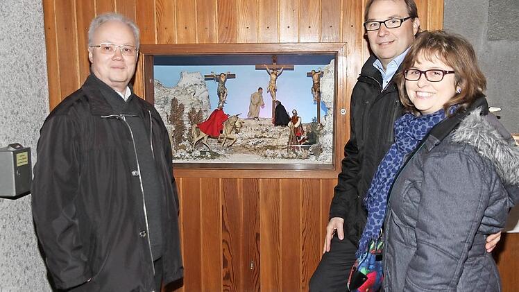 Pfarrer Pater Franz Weiherstraß (l.), Dieter Herden und dessen Frau Marion stehen vor der Krippe.
