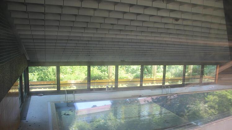 Ein Blick durch die trüb gewordenen Fensterscheiben des Münnerstädter Hallenbades auf das leere Schwimmbecken. Foto: Heike Beudert