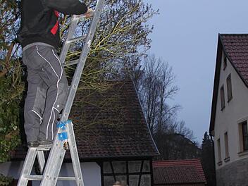 Markus Schaffran von der Firma Elektro Hetz montiert am Weiherdamm eine private Straßenbeleuchtung. Rudolf Hetz hält die Leiter. Foto: Stephan Tiroch