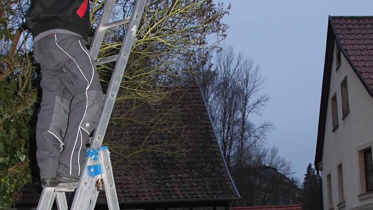 Markus Schaffran von der Firma Elektro Hetz montiert am Weiherdamm eine private Straßenbeleuchtung. Rudolf Hetz hält die Leiter. Foto: Stephan Tiroch