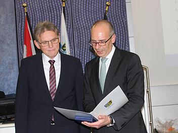 Landrat Christian Meißner überreichte Günter Ebert (links) Ehrenmedaille und Urkunde. Anschließend durfte sich der scheidende Geschäftsleiter in das Goldene Buch des Landkreises eintragen. Foto: Popp