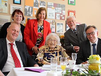 Charlotte Neumann (Mitte) feierte ihren 100. Geburtstag mit ihrer Familie, Sohn Frank (2. v. r.), Schwiegertochter Kirsten (4. v. r.), Centrumsleiterin Johanna Auerbeck (2. v. l.), Bürgermeister Gerald Brehm (l.) und Landrat Alexander Tritthart (r.). Foto: Franziska Rieger