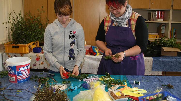 Nicole Geier und Carolin Bock, die in wenigen Wochen Prüfungen schreiben, binden Kränze und fertigen hübsche Deko-Sträußchen.