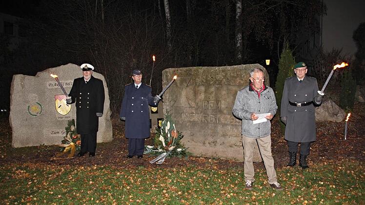Fackelträger der Marine, der Luftwaffe und der Reservisten von Ebern umrahmten am Freitagabend die Ansprachen der Redner am Ehrenmal. Vertreter der früheren Bundeswehrbataillone, der Kirche und der Stadt gedachten im Vorfeld des Volkstrauertages der Opfer von Gewalt, Krieg, Terror und Vertreibung. Foto: Helmut Will