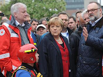 Seehofer und Merkel beim Hochwasser in Passau - der Übergang vom Krisenmanagement zum Wahlkampf ist in solchen Situationen oft fließend. Foto: Andreas Gebert/dpa