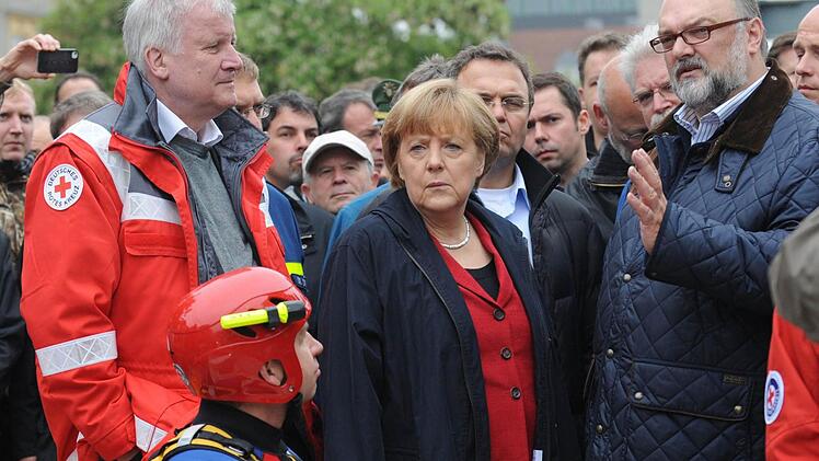 Seehofer und Merkel beim Hochwasser in Passau - der Übergang vom Krisenmanagement zum Wahlkampf ist in solchen Situationen oft fließend. Foto: Andreas Gebert/dpa