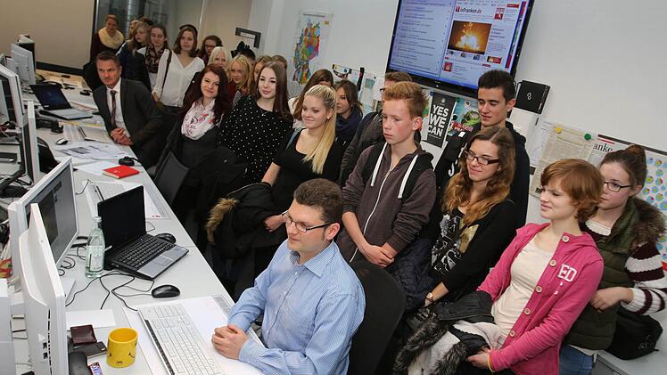 Die Teilnehmer des "Schnupperkurs Journalismus" schauen Nachrichtenchef Adrian Grodel über die Schulter. Foto: Barbara Herbst