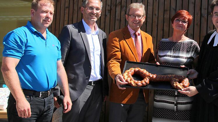Mit der Schlüsselübergabe wurde gestern die neuerbaute evangelische Kindertagesstätte "Villa Kunterbunt" in Weitramsdorf offiziell eröffnet. Die Architekten Matthias Hanstein und Lutz Wallenstein (Archi Viva) hatten für Bürgermeister Wolfgang Bauersachs, Leiterin Karin Döll und Pfarrer Michael Meyer zu Hörste gleich einen großen, essbaren Schlüssel mitgebracht. Foto: Bettina Knauth