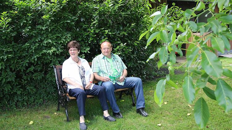 Gertraud und Hans Heinlein haben es sich auf einer Bank im Garten von Peter Janson gemütlich gemacht. Foto: Michael Stelzner