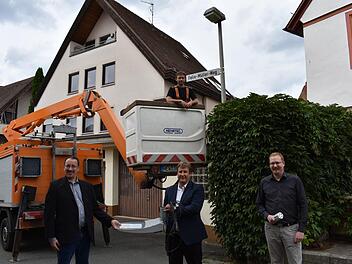Bürgermeister Martin Walz (CSU), Ralf Schwarz, Kommunalberater der  Bayernwerk-Netz-Gesellschaft und  Dominic Tschampel, der Lichtberater der Bayernwerk (v. l.); oben im Hubsteiger ist Stefan Wittmann von der Firma Schwarzbach und  Wittmann, die für das Bayernwerk die Lampen umrüstet.    Foto: Petra Malbrich