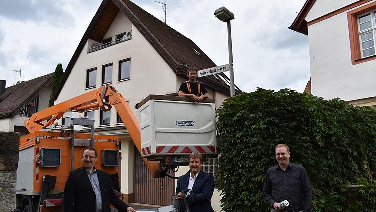 Bürgermeister Martin Walz (CSU), Ralf Schwarz, Kommunalberater der  Bayernwerk-Netz-Gesellschaft und  Dominic Tschampel, der Lichtberater der Bayernwerk (v. l.); oben im Hubsteiger ist Stefan Wittmann von der Firma Schwarzbach und  Wittmann, die für das Bayernwerk die Lampen umrüstet.    Foto: Petra Malbrich