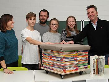 Gerade noch rechtzeitig zur Hauptversammlung wurde der Prototyp eines  Hockers  aus nicht mehr benötigten Schulbüchern fertig. Schulpatin Susanne Müller, Marketingleiter Jannis Höppel, Schulpate Manuel Fischer, Abteilungsleiterin-Finanzen Sophie Hümpfner, Vorstandsvorsitzende Nora Diem und Wirtschaftspate Gunther Krines (von links) freuen sich über das gelungene Werkstück.  Günther Geiling
