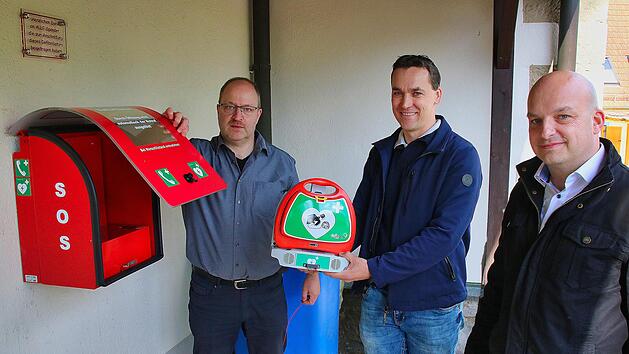 Am Dorfgemeinschaftshaus im Stadtteil Kleinwenkheim wurde jetzt ein  Defibrillator installiert, der bei plötzlichem Herzstillstand Leben retten  kann. Jürgen Müller vom Zentrum für Telemedizin in Bad Kissingen (links)  gab ausführliche Einweisungen in das Gerät. Die Initiative zu seiner  Anschaffung hat Stadtrat und Ortsreferent Oliver Jurk (Mitte) ergriffen.  Rechts Bürgermeister Michael Kastl. Foto: Dieter Britz