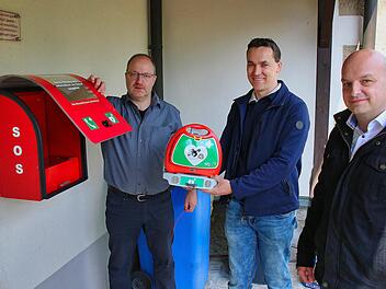 Am Dorfgemeinschaftshaus im Stadtteil Kleinwenkheim wurde jetzt ein  Defibrillator installiert, der bei plötzlichem Herzstillstand Leben retten  kann. Jürgen Müller vom Zentrum für Telemedizin in Bad Kissingen (links)  gab ausführliche Einweisungen in das Gerät. Die Initiative zu seiner  Anschaffung hat Stadtrat und Ortsreferent Oliver Jurk (Mitte) ergriffen.  Rechts Bürgermeister Michael Kastl. Foto: Dieter Britz