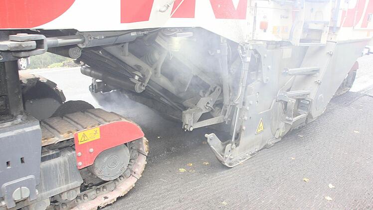 Hinter den Raupenketten wird der Asphalt maschinell abgefräst.  Foto: Friedwald Schedel