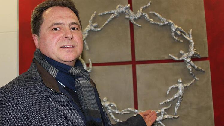 In der Firma geht es um das Miteinander, erklärt Chef Stürmer vor dem Kunstwerk, das eben dieses ausdrücken soll. Foto: Schreiber