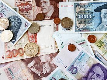 D-Mark-Geldscheine und Münzen auf einem Tisch. Die Bundesbürger horten immer noch Milliarden der alten Währung zuhause, hat die Bundesbank errechnet.  Foto: Bernd Wüstneck/dpa