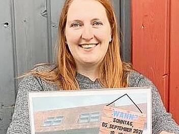 Alexandra Rehm trägt das Plakat zum Kinder- und Jugendflohmarkt am 5. September.