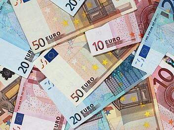 Banknoten auf einem Haufen. Experten rechnen mit wieder steigenden Preisen in Deutschland. Foto: Jens Wolf, dpa