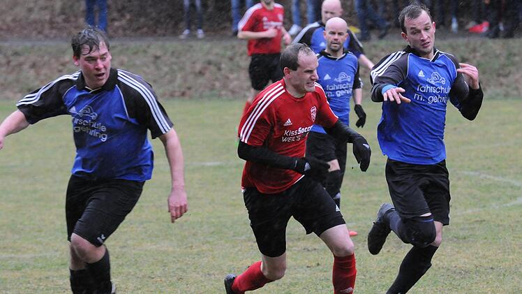 Die wetterbedingten Qualen des Spieltags stehen dem Oberthulbaer Markus Markert (am Ball) und dem Obereschenbacher  Florian Holzinger (rechts) ins Gesicht geschrieben.ssp