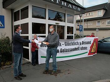 Alexander Kaiser (vorne rechts) von der Initiative "Weniger Funk - glücklich und gesund" überreichte eine Liste mit Unterschriften von Gegnern des geplanten Mobilfunkmasts  aus Motschenbach und Wüstenbuchau an Bürgermeister Robert Bosch (links). Foto: Jürgen Gärtner