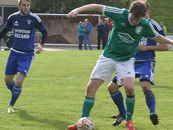 Simon Fischer (grünes Trikot), Torschütze zum 1:0 für den TV Ebern, behauptet sich trotz harter Gegenwehr am Ball.