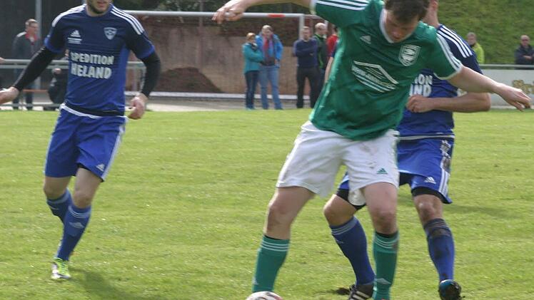 Simon Fischer (grünes Trikot), Torschütze zum 1:0 für den TV Ebern, behauptet sich trotz harter Gegenwehr am Ball.