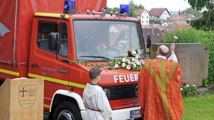 Auf dem Kirchenvorplatz segnet Kaplan Philipp Tropf das neue Fahrzeug der Schondraer Wehr.  Fotos: Oswald Türbl