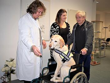 Patient Pius Amend (79) übt mit Therapiehündin Fine das Laufen; mit dabei sind Chefärztin Evelyn Müller-Bödefeld und Ergotherapeutin Lisa Gerlach. Fotos: Sigismund von Dobschütz