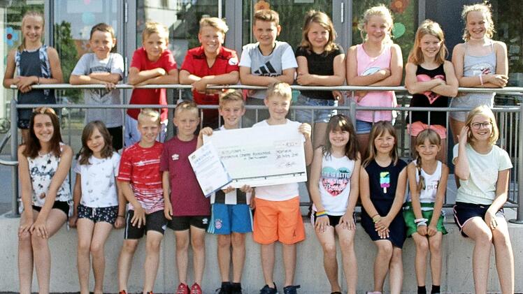 Im Sportabzeichen-Schulwettbewerb für Grundschulen in Bayern war die Grundschule Steinwiesen erfolgreich: Ein Teil der sportbegeisterten Kinder zeigt den gewonnenen Scheck über 100 Euro. Foto: Susanne Deuerling