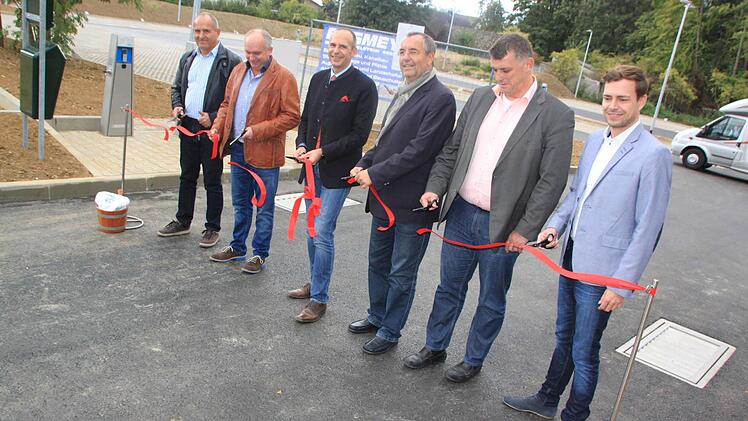 Landrat Christian Meißner (CSU, Dritter von links) und Bad Staffelsteins Bürgermeister Jürgen Kohmann (CSU, Dritter von rechts) schnitten das Band durch und übergaben den Stellplatz offiziell seiner Bestimmung. Foto: Matthias Einwag