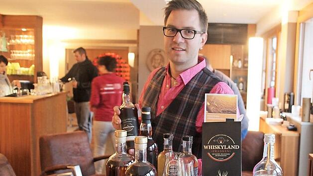 Patrick Grasser mit seinem Buch und einigen Flaschen fr&auml;nkischen und schottischen Whiskys in der "Genusslounge 89"  Foto: Rudolf G&ouml;rtler