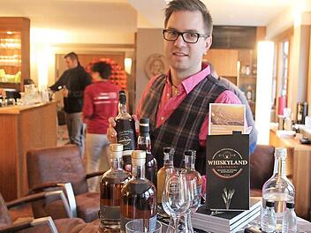 Patrick Grasser mit seinem Buch und einigen Flaschen fränkischen und schottischen Whiskys in der "Genusslounge 89"  Foto: Rudolf Görtler