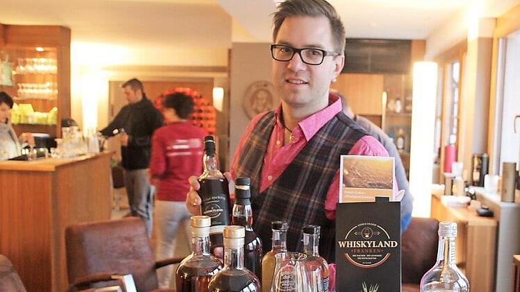 Patrick Grasser mit seinem Buch und einigen Flaschen fränkischen und schottischen Whiskys in der "Genusslounge 89"  Foto: Rudolf Görtler