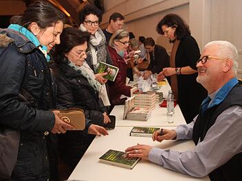 Als wahrer Publikumsmagnet zeigte sich der ehemalige Franziskanerpater und Wallfahrtspfarrer von Vierzehnheiligen, Christoph Kreitmeier. Er signierte gerne Bücher für seine Zuhörer. Foto: Günther Geiling