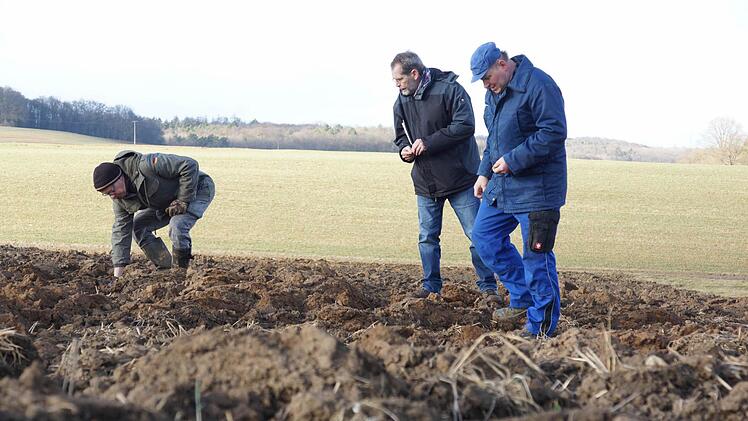 Bernd Marquard, Roland Heinlein und Wilfried Weidner suchen den umgepflügten Acker ab. Foto: Arkadius Guzy