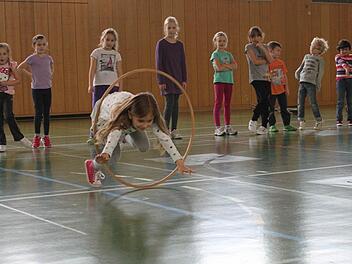 Um Kinder zu begeistern, braucht es oft nicht viel. In diesem Fall nur einen hölzernen Reifen, durch den die Kinder - wie eben Amanda - springen sollen. Foto: Katja Müller