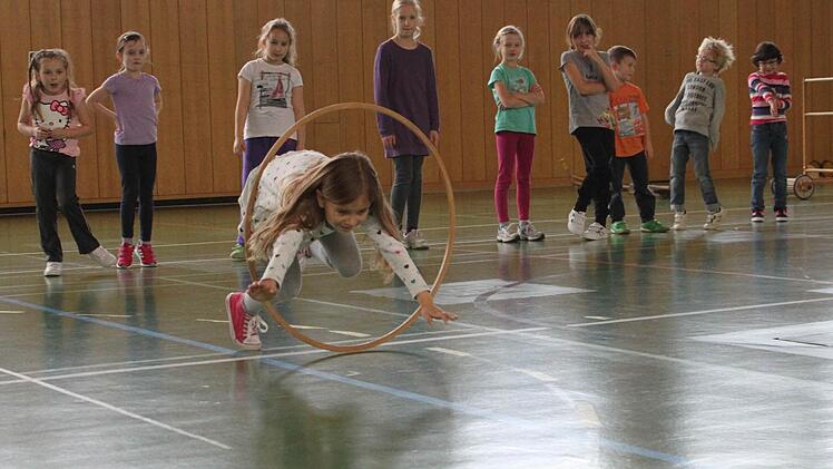 Um Kinder zu begeistern, braucht es oft nicht viel. In diesem Fall nur einen hölzernen Reifen, durch den die Kinder - wie eben Amanda - springen sollen. Foto: Katja Müller