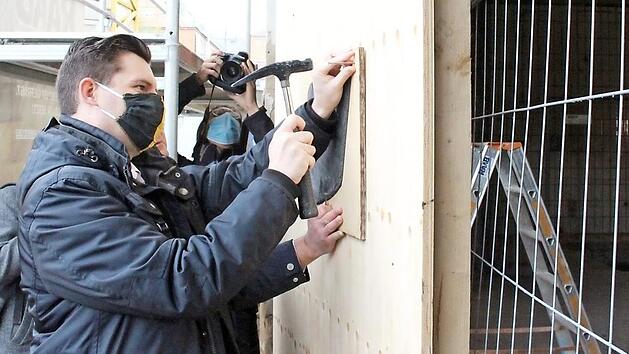 Ein paar gezielte Hammerschl&auml;ge, dann hatte Oberb&uuml;rgermeister Dominik Sauerteig die Gedenktafel an der Holzwand vor der K&uuml;hlhalle festgenagelt.  Fotos: Ulrike Nauer