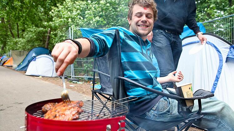 Festival-Besucher Stefan (24) aus M&uuml;nchen grillt auf dem Zeltplatz.