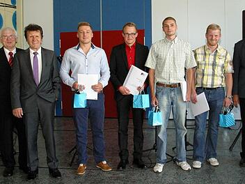 Schulleiter Anton Staudigl und IHK-Präsident Friedrich Herdan überreichten den Absolventen René Weiß, Steffen Weikard, Marcel Ruppert und Marco Kastner (von links) ihre Urkunden. Foto: Bettina Knauth