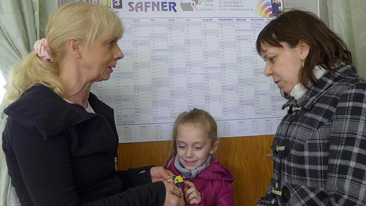 Annalena Hofmann ist die Jüngste des Tanzensembles. Sie überreicht Petra Krause ein selbst gebasteltes Geschenk, während ihre Mutter (rechts) Kostümabsprachen mit der Trainerin trifft.