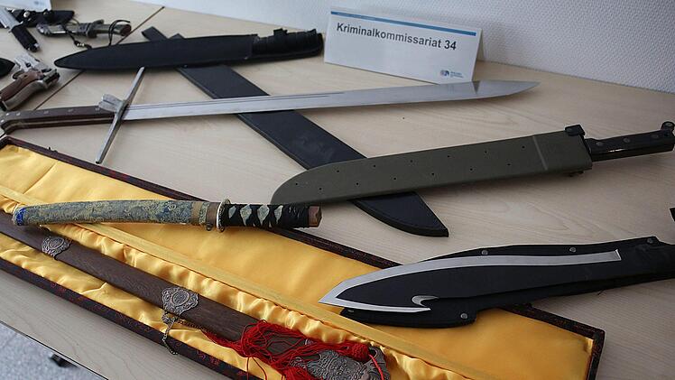 Beschlagnahmte Waffen, darunter verschiedene Messer, liegen im Polizeipräsidium Köln auf dem Tisch. Warum haben immer mehr Jugendliche ein Messer dabei? Steigt die Zahl der Messerangriffe in Deutschland tatsächlich? Symbolfoto: Oliver Berg/dpa